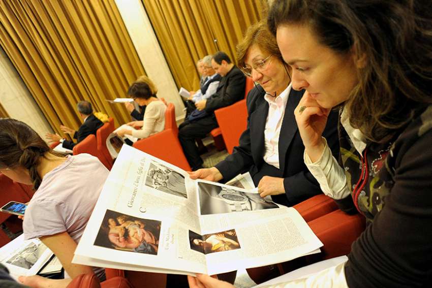 Women look at &quot;Women-Church-World,&quot; a monthly women&#039;s magazine insert in the Vatican&#039;s L&#039;Osservatore Romano newspaper, in this file photo. Claiming a lack of support for open dialogue and for an editorial line run by women, the director and editorial staff of the magazine insert have resigned. 