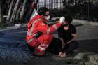 A homeless person is treated by a Red Cross worker in Rome. The Office of Papal Charities has purchased vaccines to offer inoculations in Rome to 1,200 of the poorest and most marginalized.