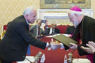 Archbishop Paul Richard Gallagher, right, secretary for relations with states within the Holy See&#039;s Secretariat of State, and Palestinian Foreign Minister Riyad al-Malki, shake hands during a meeting at the Vatican June 26. The Vatican signed its first treaty with the &quot;State of Palestine&quot; on Friday, calling for &quot;courageous decisions&quot; to end the Israeli-Palestinian conflict with a two-state solution.