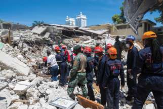 Members of a rescue team clean debris from a house in Les Cayes, Haiti, Aug. 15 following a magnitude 7.2 earthquake the previous day.