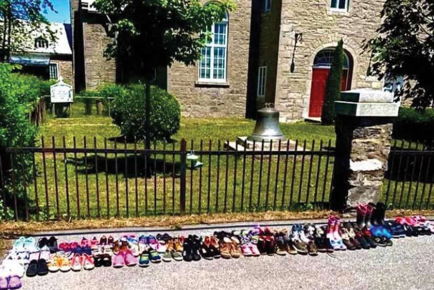 Shoes are placed outside St. Francis Xavier Mission Church in Kahnawake, Que., in memory of residential school victims. The church was vandalized earlier this month.