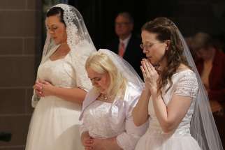 Karen Ervin, Theresa Jordan and Laurie Malashanko pause in prayer before the altar at Detroit&#039;s Cathedral of the Most Blessed Sacrament in 2017. They were consecrated into the Catholic Church&#039;s order of virgins.
