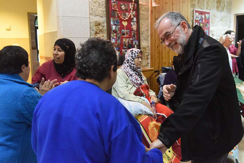  Bishop Lionel Gendron of Saint-Jean-Longueuil, Quebec, greets Palestinian women Jan. 17 in the Beit Emmaus Home for the elderly and disabled in Qubeibeh, West Bank. 