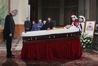 Montreal archbishop Christian Lepine pays his respects at the foot of Cardinal Jean-Claude Turcotte’s bier April 16.