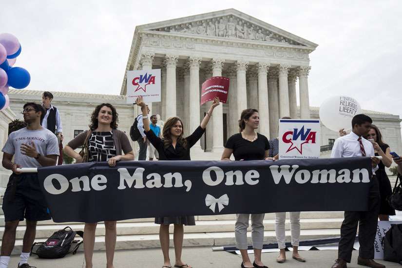 Supporters of traditional marriage between a man and a woman rally in front of the U.S. Supreme Court in Washington June 26, shortly before the justices handed down a 5-4 ruling that states must license same-sex marriages and must recognize same-sex marriages performed in other states.
