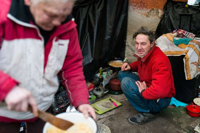 A homeless couple cooks a meal outside their makeshift shelter in late January in Budapest, Hungary. Europe&#039;s top Catholic charitable agency has published a &quot;road map for social justice and equality,&quot; urging all church members to defend the poor and marginalized.