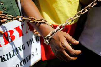A protester in Pretoria, South Africa, chains himself as part of a protest highlighting the slave trade in Libya Dec. 12.