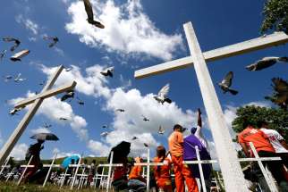 Doves fly over Filipinos lighting candles as they offer prayers and flowers at a mass gravesite in Tacloban, Philippines, Nov. 8. One year after one of the most powerful tropical cyclones ever recorded crashed across the central Philippines, church leade rs in some of the worst-hit parts looked to Pope Francis&#039; brief January visit to Leyte Island with hope, and slight trepidation.