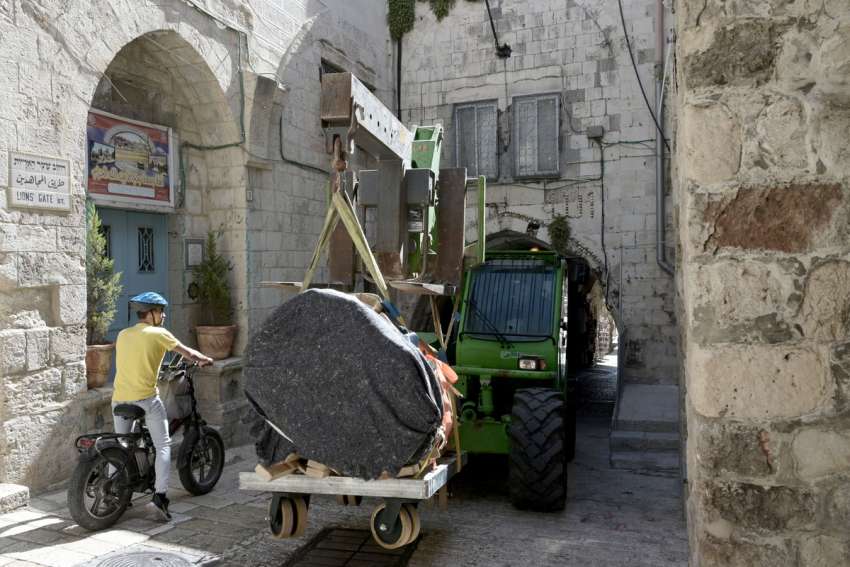 A forklift transports an ancient column from the Church of the Holy Sepulcher to the archeology wing of the Franciscan Terra Santa Museum in Jerusalem’s Old City.
