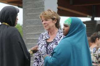 Kathy Langer, director of social concerns for Catholic Charities of the Diocese of St. Cloud, Minn., centre, talks with Maryan Ahmed and Fatumo Ukash following a Sept. 18 news conference organized by the local Somali-American community in St. Cloud after a knife-wielding man injured nine people the previous day at a shopping mall. Bishop Donald J. Kettler of St. Cloud called for prayers for those impacted by the violence.