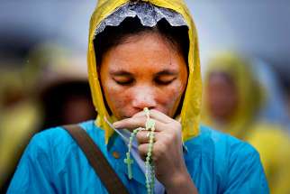 A woman prays in 2015 as Pope Francis celebrates Mass in Manila, Philippines. The prayers of the faithful, not the pope, bishops, priests or nuns, have the power to make miracles happen in the most impossible situations, Pope Francis said at his morning Mass.