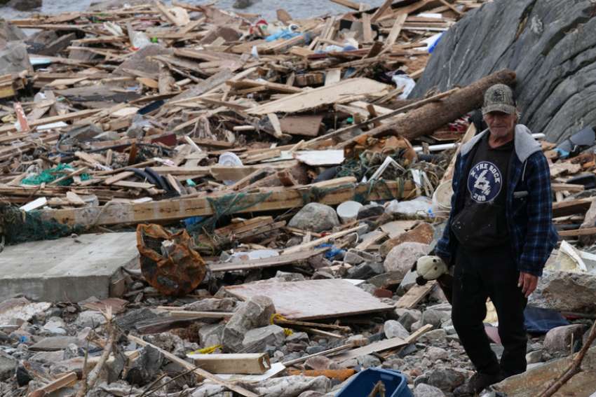 A man walks through the debris of destroyed homes along the coastline in Port Aux Basques, Newfoundland, Sept. 25, 2022. Canadian troops are being sent to assist the recovery from the devastation from Fiona, which hit the country&#039;s Atlantic provinces as a post-tropical storm and swept away houses, stripped off roofs and knocked out power.
