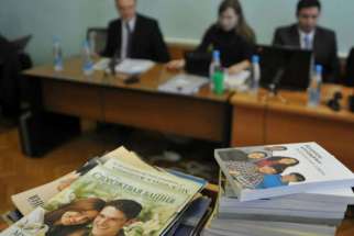 Stacks of booklets distributed by Alexander Kalistratov, left, the local leader of a Jehovah&#039;s Witnesses congregation, are seen during the court session Dec. 16, 2010, in the Siberian town of Gorno-Altaysk.