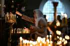 A woman lights a candle during a Christmas liturgy of the Ukrainian Orthodox Church community in Berlin, Germany on January 7, 2023.