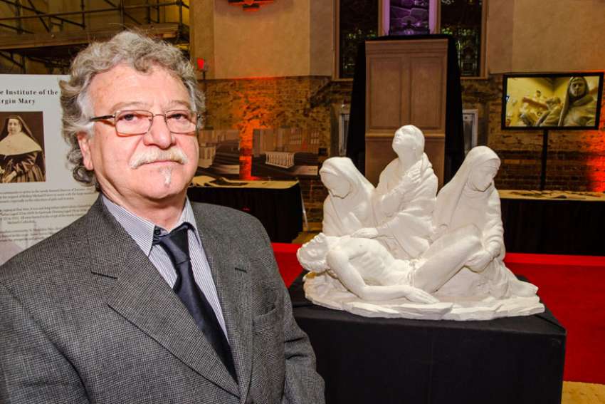 Lawrence Voaides-Cajabn posing with a model of Pietà December 2015. The final marble statue arrived at St. Michael&#039;s Cathedral&#039;s crypt Nov. 19.