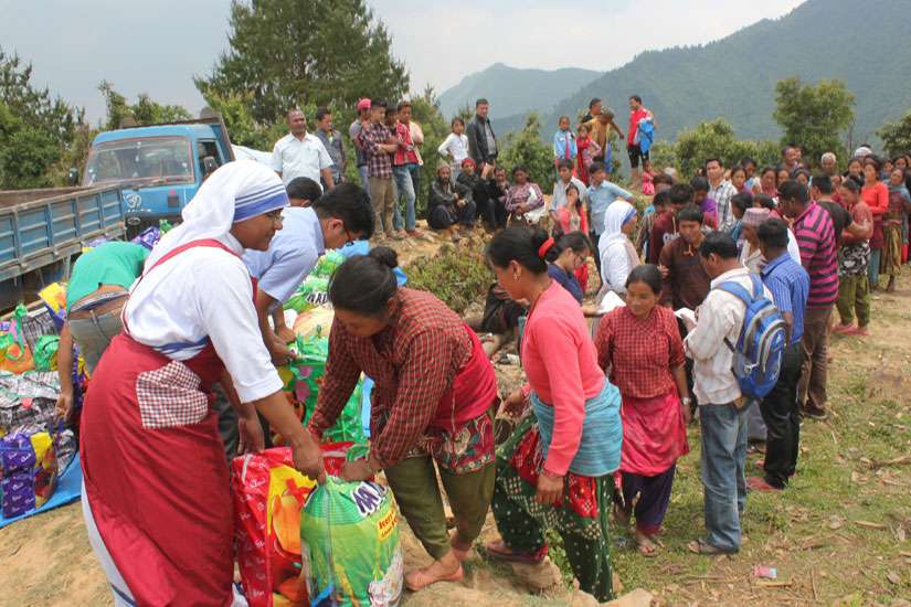 A member of the Missionaries of Charity helps distribute relief items to earthquake victims May 16 in the mountains overlooking Kathmandu Valley in Nepal. 