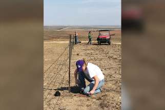 Emma Joyce, a junior at Maur Hill-Mount Academy in Atchison, Kan., and a parishioner of St. Benedict Church in Bendena, Kan., helps repair a fence line March 22 at a ranch near Ashland, Kan., The ranch had sustained damage from a devastating wildfire that swept through that portion of the state in early March.