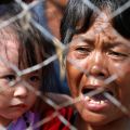 A woman cries as she and her grandchild wait to be airlifted to Manila at the airport in Tacloban, Philippines, Nov. 14. Typhoon Haiyan killed an estimated 2,500 people and left hundreds of thousands displaced in the central Philippines.