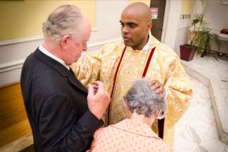 Fr. Ricardo Davis blesses well-wishers after he was ordained to the priesthood May 9 at St. Michael’s Cathedral.