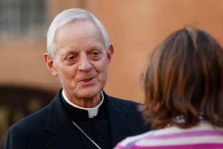Cardinal Donald W. Wuerl of Washington speaks with a journalist as he arrives for the morning session of the extraordinary Synod of Bishops on the family at the Vatican Oct. 14. 