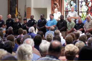 Police officers attend a July 17 vigil at St. John the Baptist Church in Zachary, La., for the fatal attack on policemen in Baton Rouge, La. Since the tragedy unfolded in Baton Rouge, the Catholic community has been at the forefront of efforts for peace and healing.