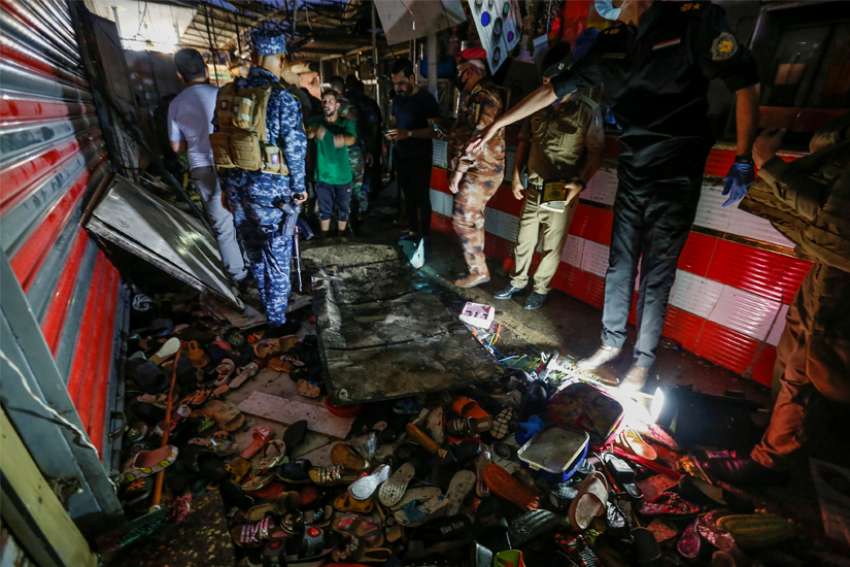 Iraqi security forces inspect the site of a suicide bombing in Baghdad July 19, 2021. Pope Francis expressed his condolences after the bombing, which occurred in a busy market and claimed dozens of lives.