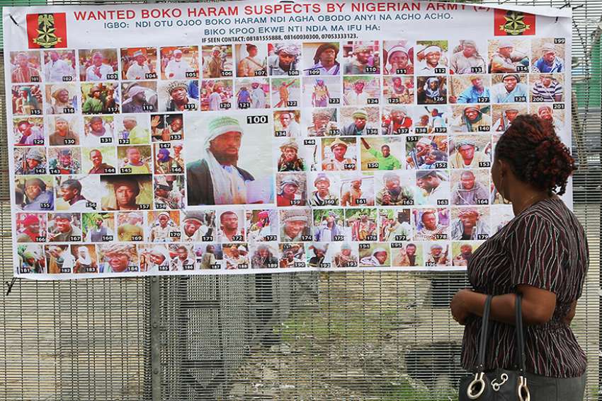  A woman in Bayelsa, Nigeria, reads a Nigerian army poster picturing wanted Boko Haram suspects May 19. 