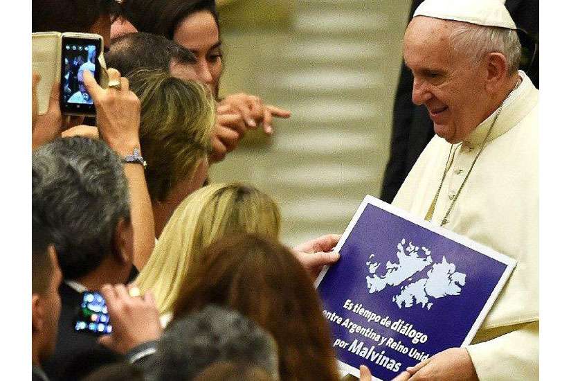 Pope Francis is handed a sign urging dialogue about the ownership of the Falkland Islands.