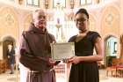 Franciscan Fr. Damian MacPherson awarded Ruthann J. Lemonius her second-place certificate and a new Kobo Aura H2O eReader for her winning essay.