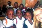 Joanna Baumgartner is surrounded by Haitian school children outside the school in Ouanaminthe.