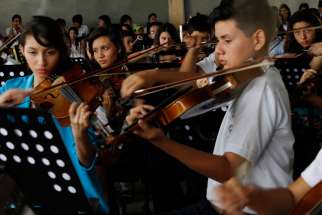 Members of the youth symphony orchestra rehearse at PolÃ­gono Industrial Don Bosco, located in a crime-ridden area of San Salvador, El Salvador.