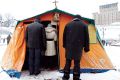 People enter a makeshift chapel on the Maidan, Independence Square, in Kiev. Tent-chapels have become common whenever Ukrainians are protesting against the government of President Viktor Yanukovich and his decision to walk away from an agreement with the European Union that was 11 years in the making.