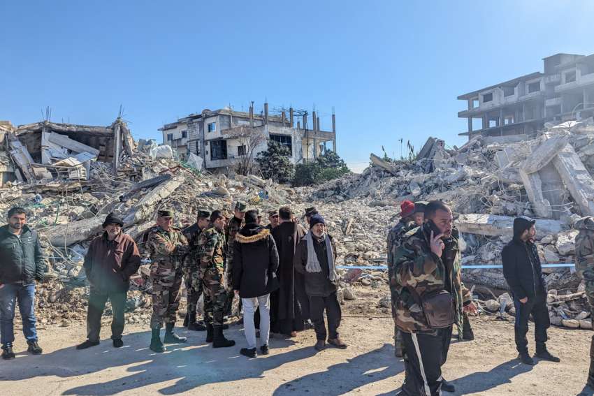 Members of the Syrian army, talking to a Franciscan priest from the Franciscan convent in the Syrian port city of Lattakia outside collapsed homes after the earthquake.