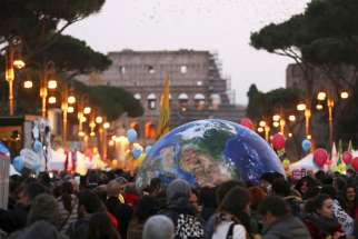 Protesters carry a globe-shaped balloon in front of Rome&#039;s Colosseum during a Nov. 29 rally.