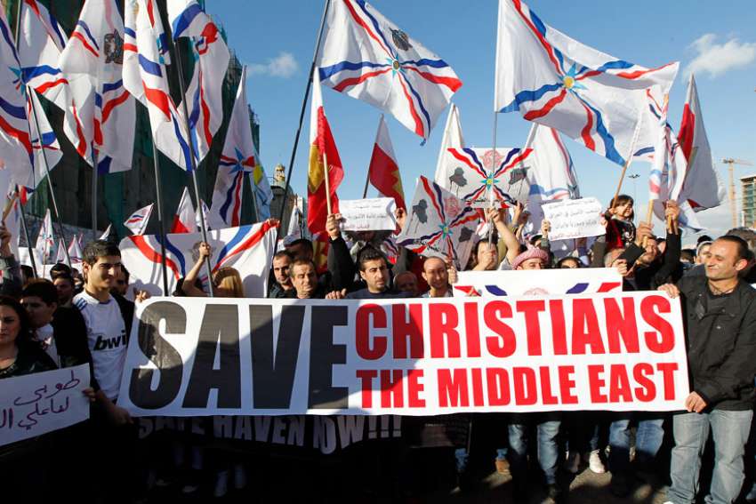 Assyrian Christians, who had fled Syria and Iraq, carry placards and wave Assyrian flags during a gathering in late May in front of U.N. headquarters in Beirut.
