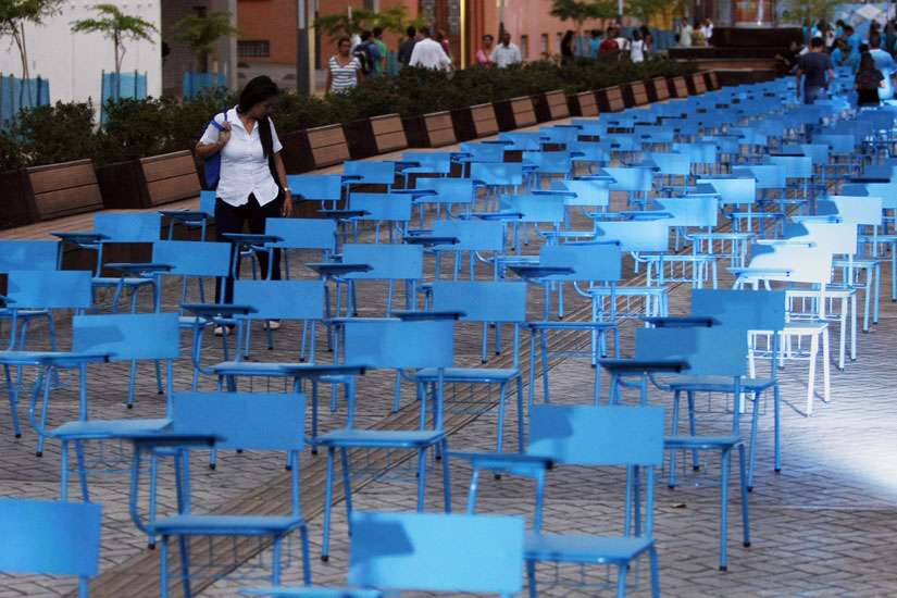 A girl walks among a blue chairs installation for Human Trafficking Awareness Day in Cali, Colombia, July 30. The chair represent more than 20 million men, women and children who are victims of human trafficking worldwide.