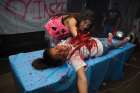 Students pour on the spook and gore inside a haunted house at a Halloween carnival in Tucson, Ariz.