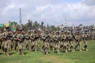 Kurdish fighters in Qamishli, Syria, take part in a military parade March 28, 2019. Groups representing Syriac Christians in northeast Syria are appealing for prayer, fearful that Turkey plans to make good its numerous threats to invade the region with its military forces.