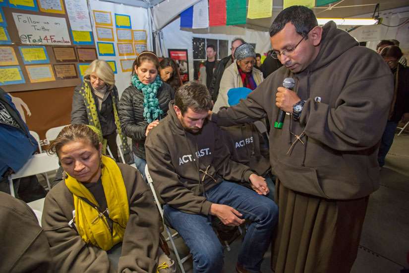 Franciscan Brother Juan Turios of Action Network prays in 2013 with immigration reform advocates in Washington. To help appreciate and better promote the vocation of religious brothers, the Vatican released a 50-page reflection on the importance of their life and mission of evangelization, fraternity and sacrifice.