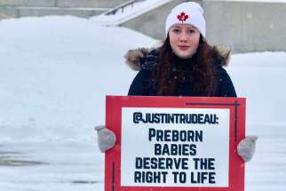 A supporter holds a sign at a rally in front of the Supreme Court of Canada in Ottawa, Jan. 26, 2023.