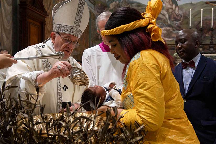Pope Francis baptizes one of 27 babies during a Mass on the feast of the Baptism of the Lord in the Sistine Chapel at the Vatican Jan. 13.