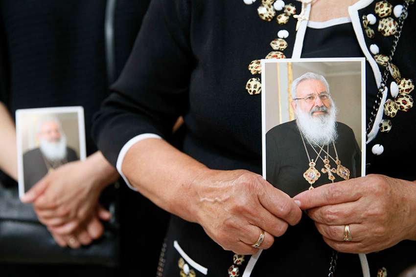 A woman holds an image of Ukrainian Cardinal Lubomyr Husar during his June 5 funeral Mass at the Patriarchal Cathedral of the Resurrection of Christ in Kiev. Cardinal Husar died May 31 at the age of 84.