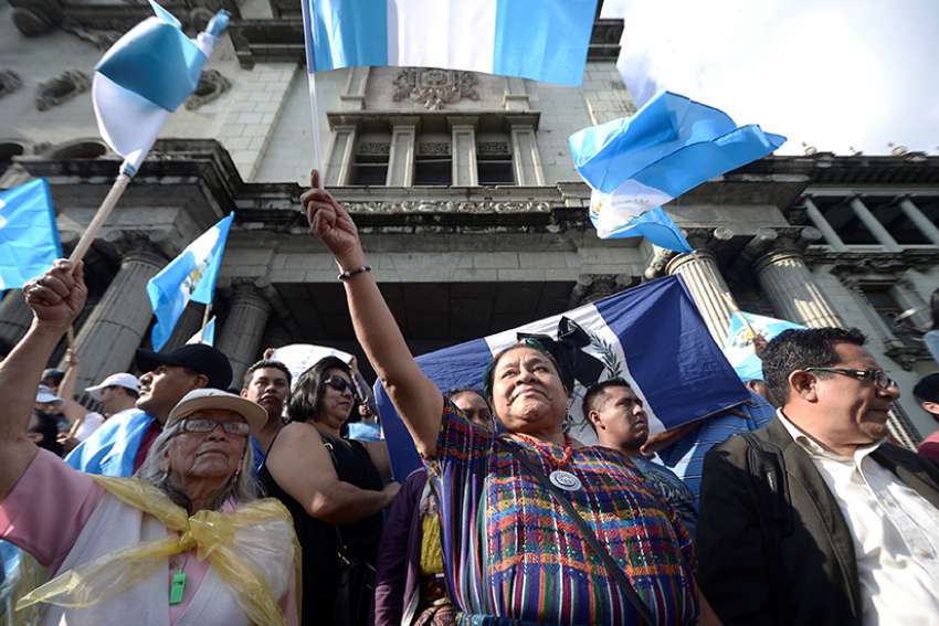 Nobel Peace Prize winner Rigoberta Menchu holds a Guatemalan flag as she joins an Aug. 28 protest against President Jimmy Morales in front of the National Palace in Guatemala City. The Guatemala bishops have criticized the president for trying to oust the internationally appointed commissioner against corruption and impunity.