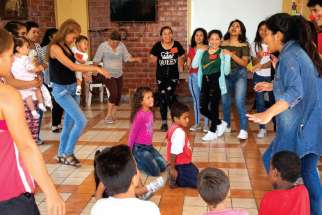 Venezuelan migrants dance during a Christmas event Dec. 16 at the Scalabrini welcome centre in Lima, Peru. A local parish organized the event for migrants living at the centre. 