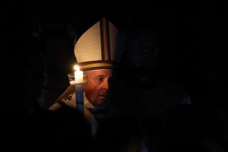 Pope Francis carries a candle in procession as he arrives to celebrate the Easter Vigil in St. Peter&#039;s Basilica at the Vatican April 20, 2019. 