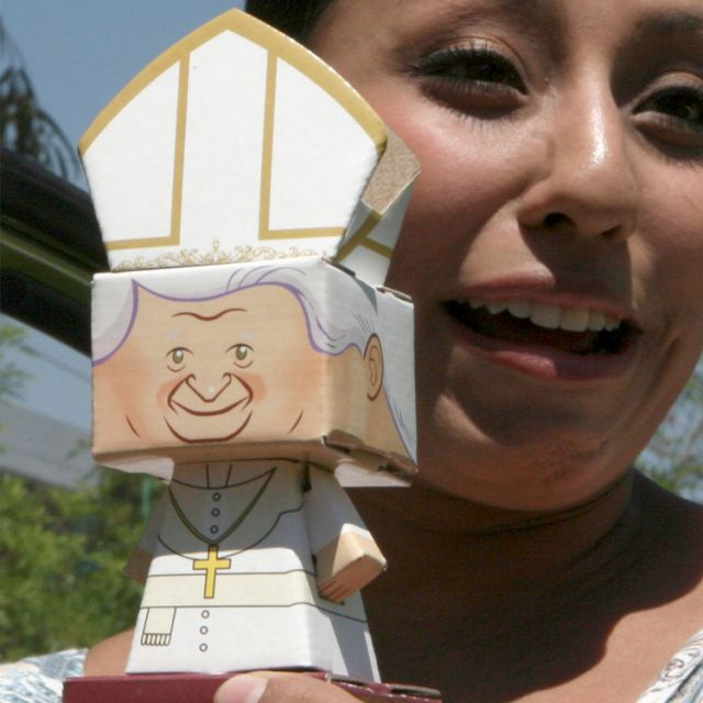 Alejandra Farfan holds a paper figurine of Pope Benedict XVI for sale in Leon, Mexico, March 15. The pope will arrive in Leon March 23 to begin his six-day visit to Mexico and Cuba. 