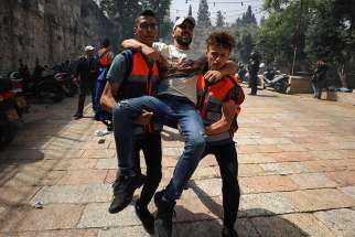 A wounded Palestinian protester is evacuated during clashes with Israeli police outside Al-Aqsa Mosque at the Temple Mount complex in the Old City of Jerusalem May 10, 2021.