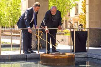 Fr. Massey Lombardi joins Toronto Mayor John Tory in relighting the eternal flame at the peace garden in Nathan Phillips Square May 18.