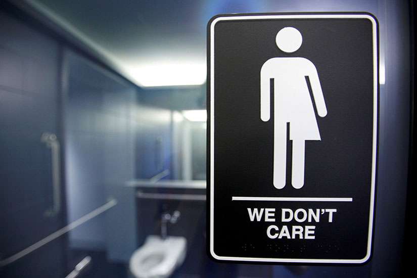 A sign protesting a recent North Carolina law restricting transgender bathroom access is seen in the bathroom stalls at the 21C Museum Hotel in Durham, N.C., on May 3, 2016.