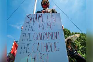 A protester in Toronto takes the RCMP, the federal government and the Church to task for residential schools.